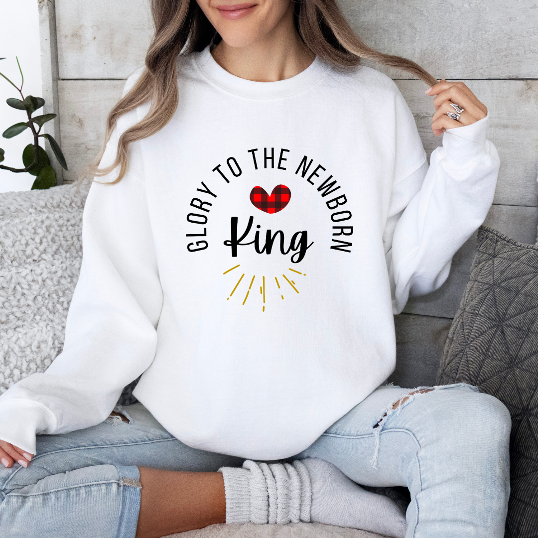 White crewneck sweatshirt that says, "Glory to the newborn King" with gold embellishment and buffalo plaid red heart.