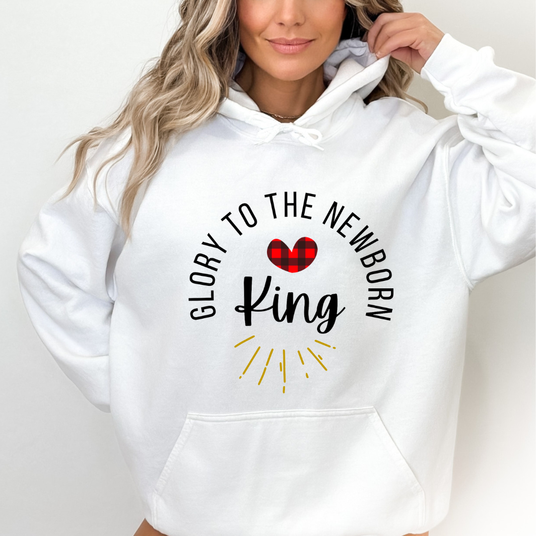 White hooded sweatshirt that says, "Glory to the newborn King" with gold embellishment and buffalo plaid red heart.