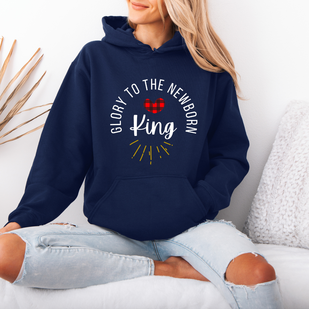 Navy blue hooded sweatshirt that says, "Glory to the newborn King" with gold embellishment and buffalo plaid red heart.