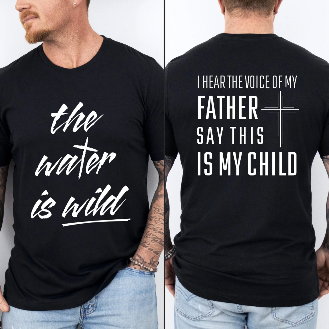 Black crewneck t-Shirt that says, “the water is wild”. The “t” in water is a cross. The back says, “I hear the voice of my father say this is my child” with a large cross in the middle.