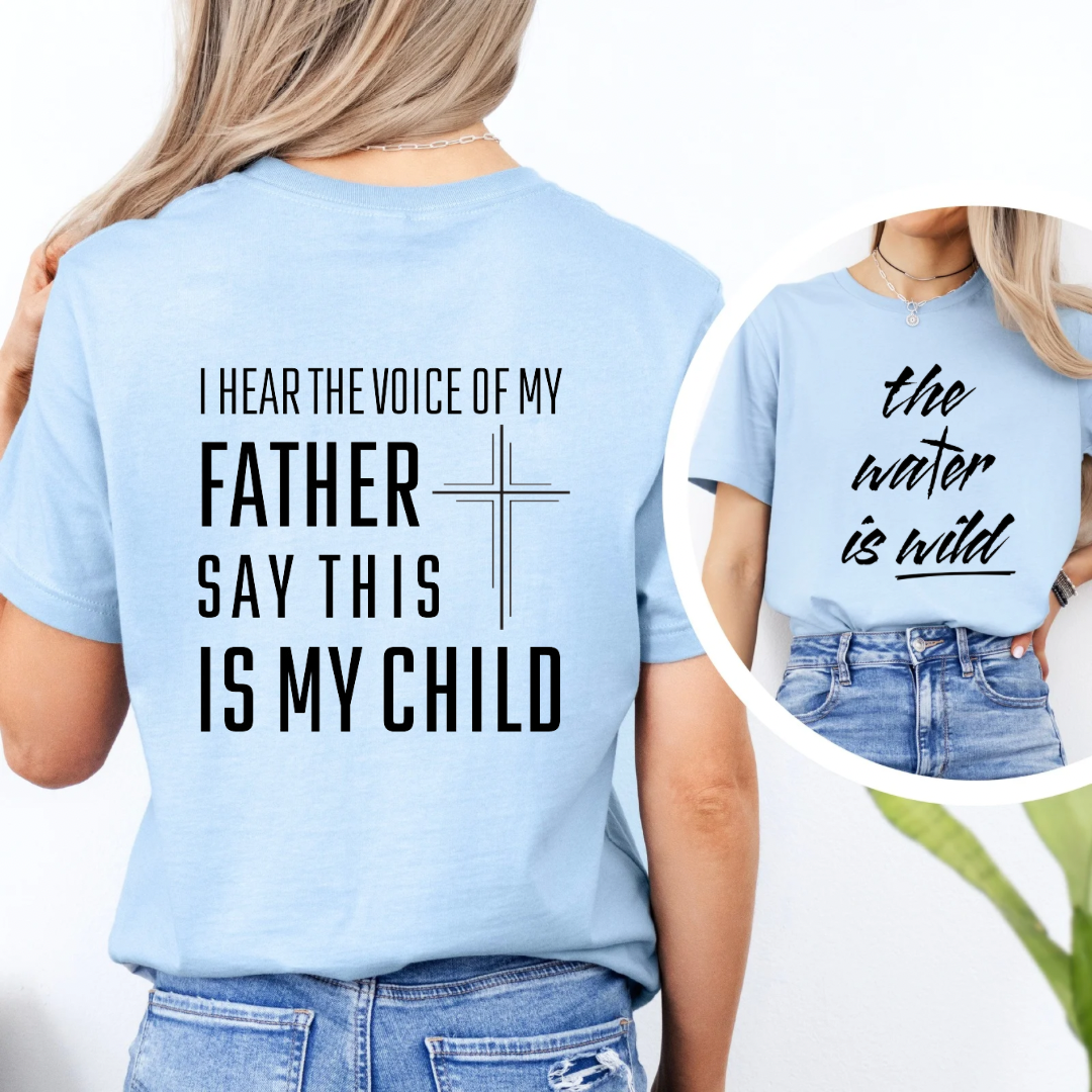 Baby blue crewneck t-Shirt that says, “the water is wild”. The “t” in water is a cross. The back says, “I hear the voice of my father say this is my child” with a large cross in the middle.