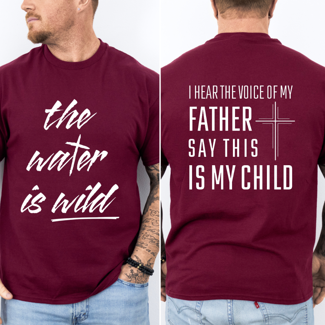 Maroon crewneck t-Shirt that says, “the water is wild”. The “t” in water is a cross. The back says, “I hear the voice of my father say this is my child” with a large cross in the middle.