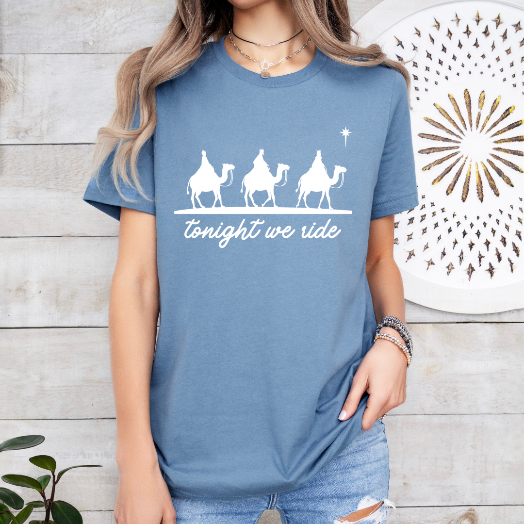 Steel blue crewneck t-shirt that says, “tonight we ride” with an image of the three wisemen riding on camels towards the Christmas star.