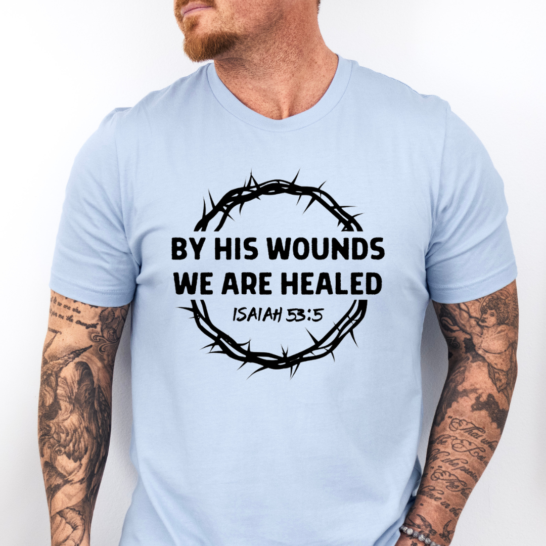 Baby blue Crewneck t-shirt that says, “by His wounds we are healed. Isaiah 53:5.”