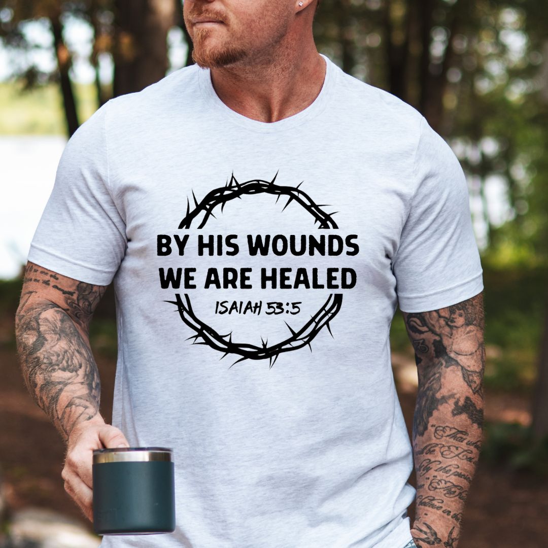 Ash white Crewneck t-shirt that says, “by His wounds we are healed. Isaiah 53:5.”