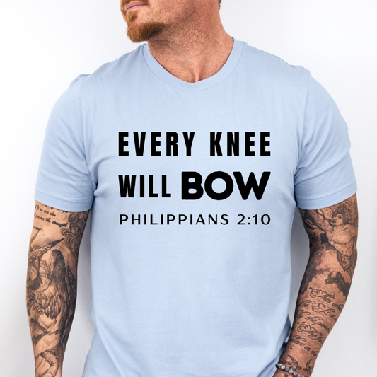 Baby blue crewneck t-shirt that says, “every knee will bow. Philippians 2:10.”