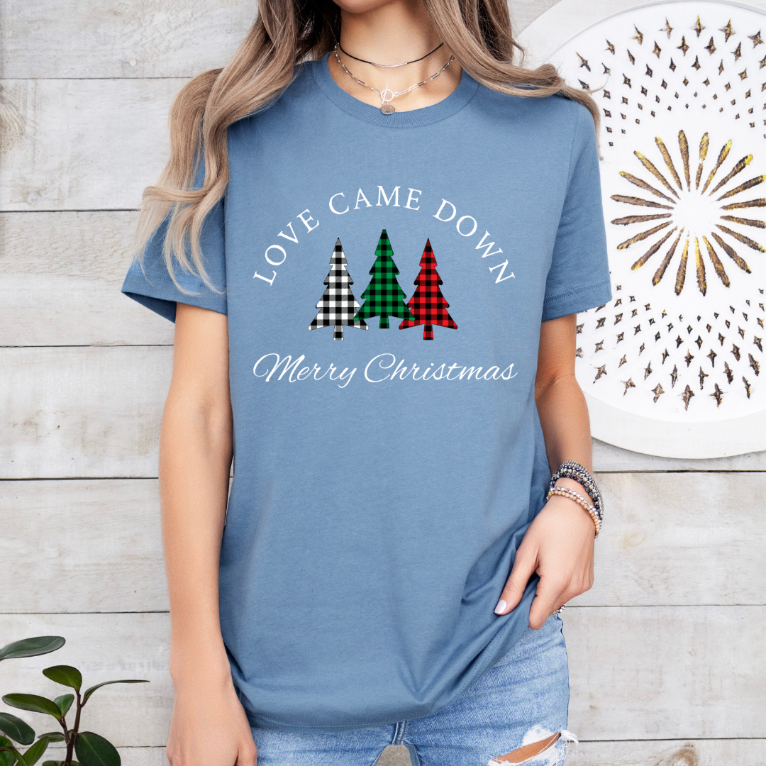 Steel blue crewneck t-shirt that says, "Love came down. Merry Christmas." It features 3 Christmas trees in buffalo plaid green, red and white.