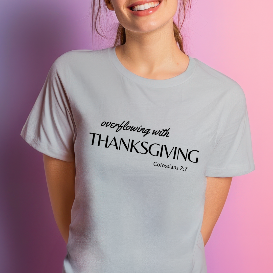 Grey crewneck t-shirt that says, "overflowing with thanksgiving. Colossians 2:7." 